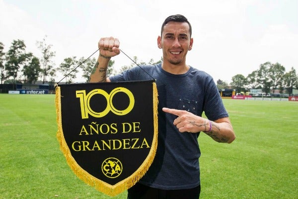 Rubens Sambueza señala la bandera de América con la leyenda de los 100 años