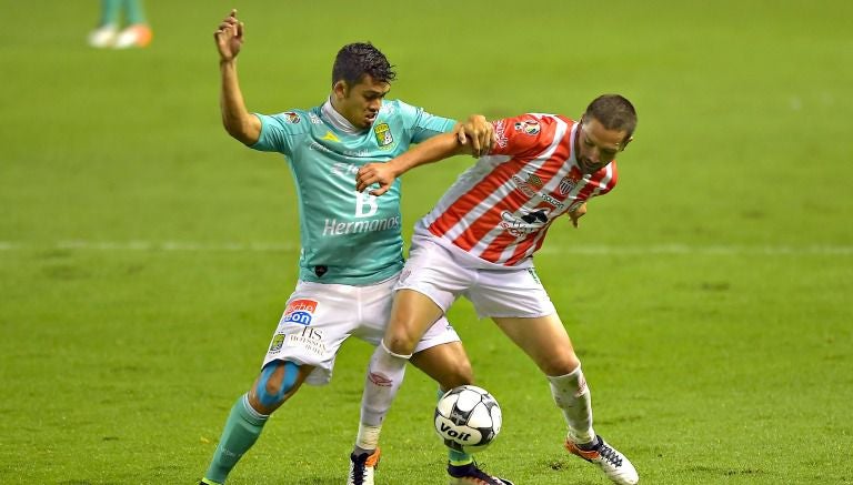 Andrés Andrade y Erik Vera pelean por un balón