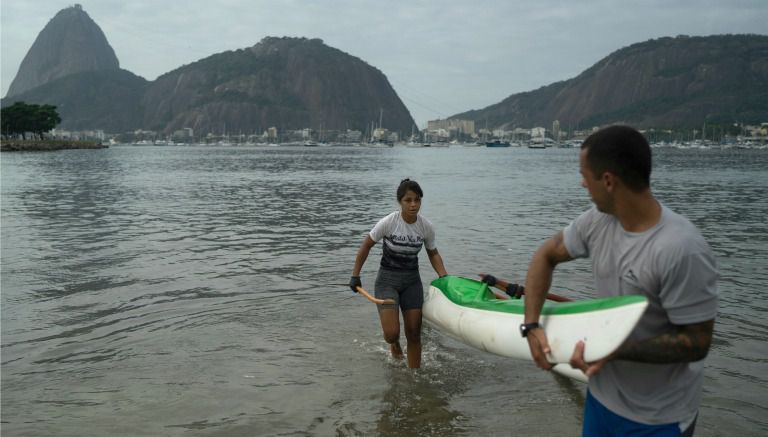 La canoísta brasileña Sarah Almeida de Freitas junto a su entrenador en la Bahía Guanabara