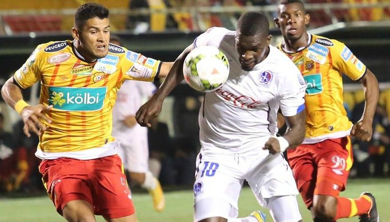 Luis Omar Hernández (amarillo y rojo) disputa un balón en juego de Herediano