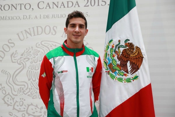 Rommel Pacheco posa junto a la bandera de México