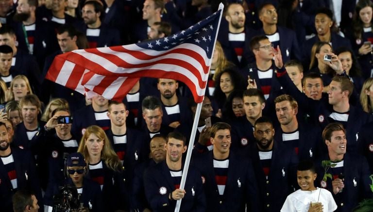 Michael Phelps lleva la bandera de los Estados Unidos