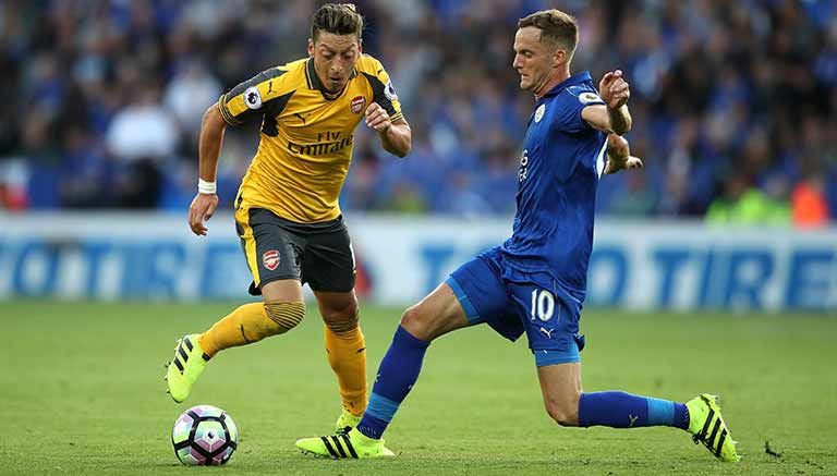 Mesut Özil, del Arsenal, intenta evitar la entrada de Andy King