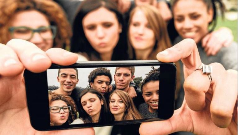 Grupo de millenials se toma una selfie con un smartphone