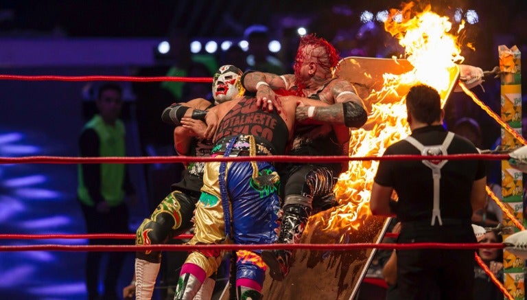 Psycho Clown impacta contra la mesa a Pagano y Dr. Wagner Jr.