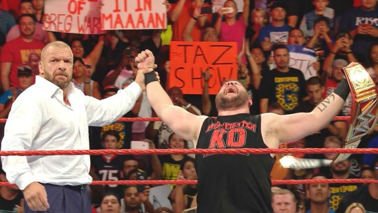 Kevin Owens festeja con Triple H el triunfo