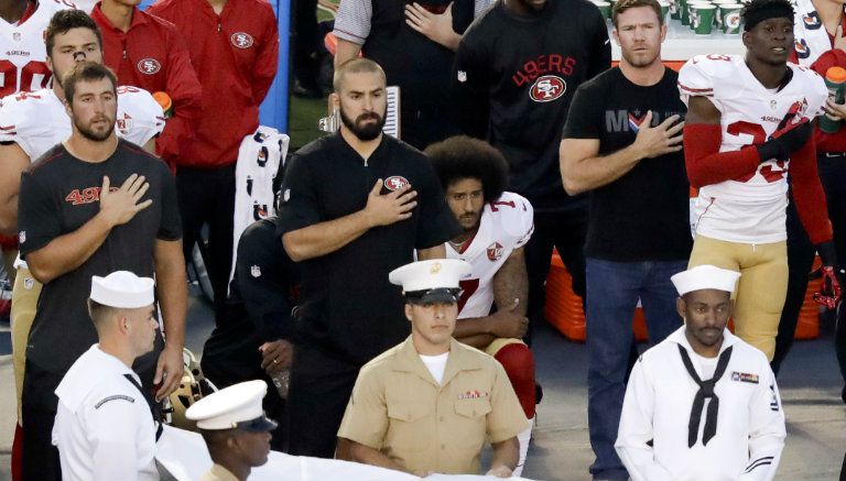 Kaepernick con rodilla en el piso durante el himno de Estados Unidos