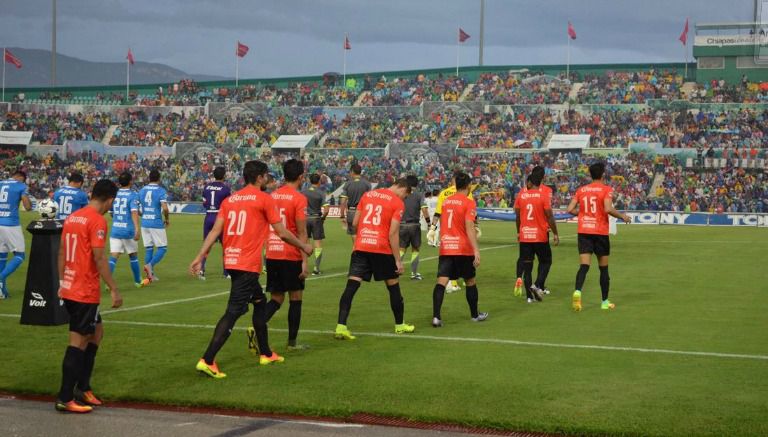 Jugadores de Chiapas saltan al terreno de juego con la playera color naranja