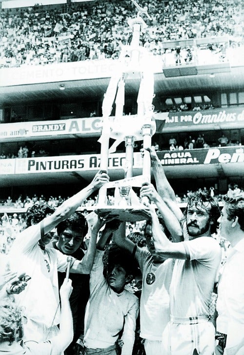 Los jugadores de América cargan un trofeo ganado por el Club en el estadio Azteca