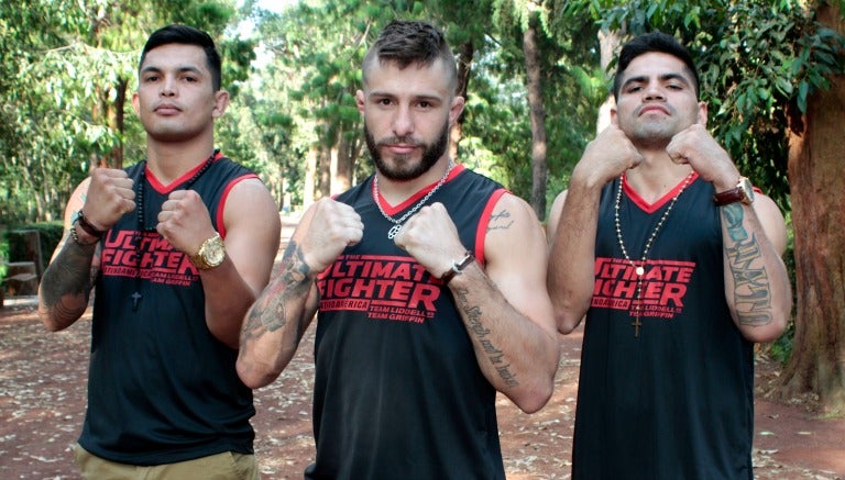 Peleadores de la UFC posan con los puños en alto