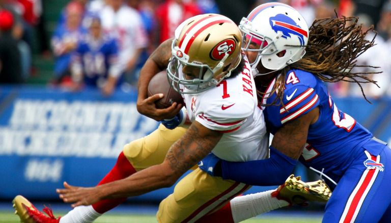 Colin Kaepernick es abordado por Stephon Gilmore en el juego entre 49ers y Bills