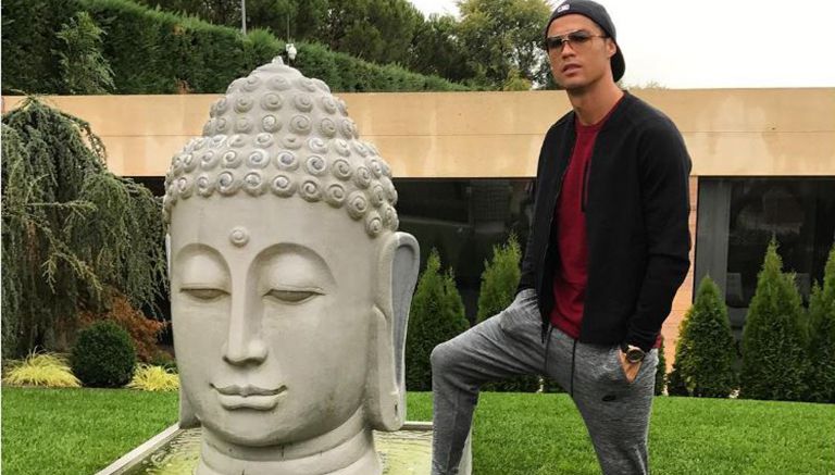 Cristiano Ronaldo posa junto a estatua de Buda