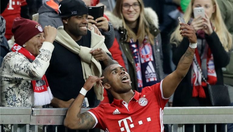 Douglas Costa se toma una selfie con aficionados después de anotar con el Bayern