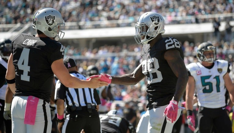 Derek Carr y Latavius Murray se dan la mano tras anotar frente a Jaguares