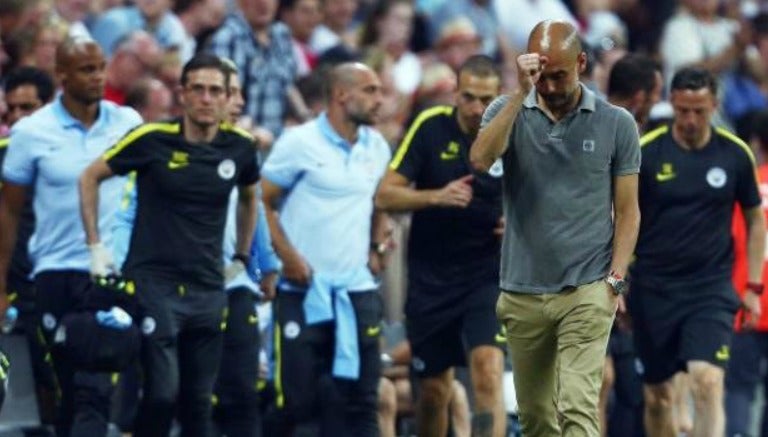 Guardiola camina junto a su banca y sus asistentes