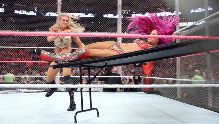 Charlotte impacta contra la mesa a Sasha Banks