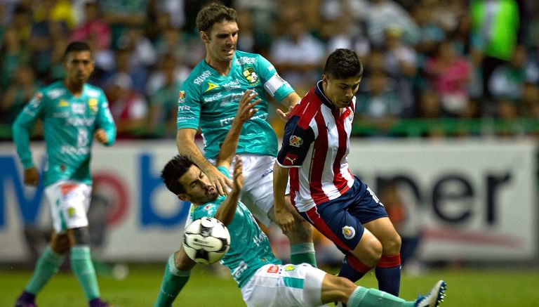 Jugadores del León disputan un balón en el duelo contra Chivas