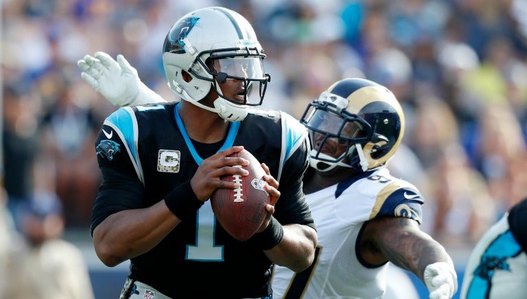 Cam Newton con el balón durante el juego contra Rams