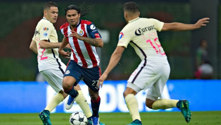 Carlos Peña conduce un balón ante la marca de Pablo Aguilar