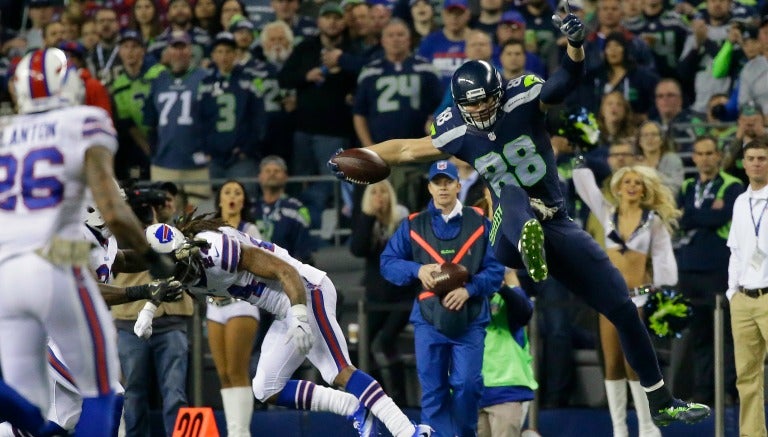 Graham atrapando con una mano el balón para un TD