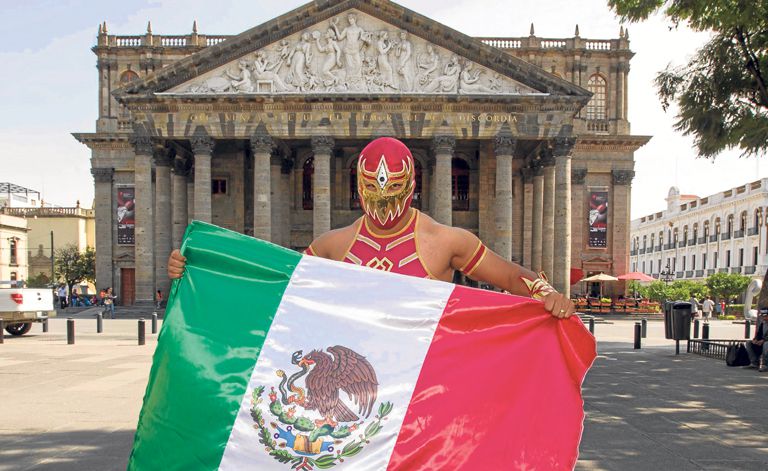 Gran Metalik sosteniendo la bandera de México