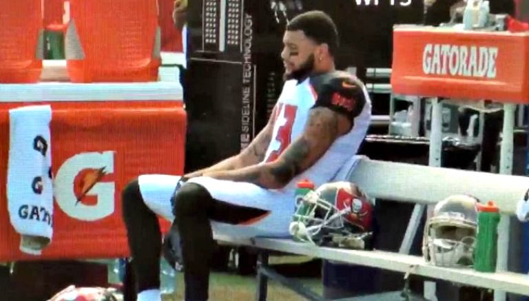 Mike Evans permanece sentado durante el Himno Nacional de EU