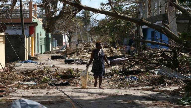 Una mujer camina por una zona de desastre tras el paso de Matthew