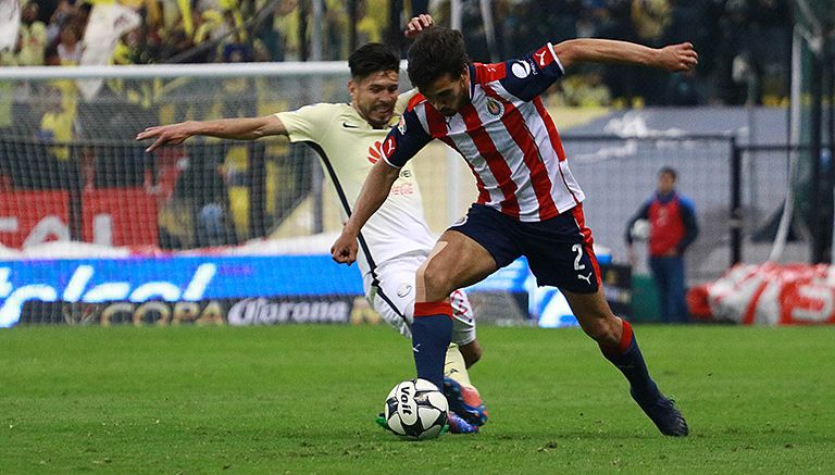 Peralta y Alanís pelean por el balón en el pasado Clásico