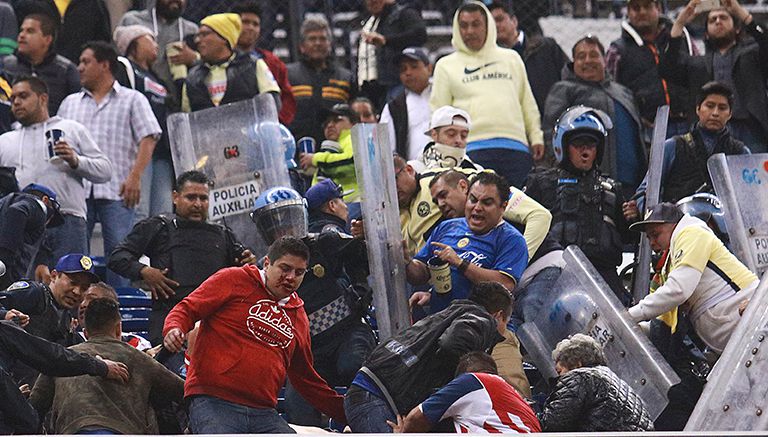 Aficionados se enfrentan con policías en el Azteca