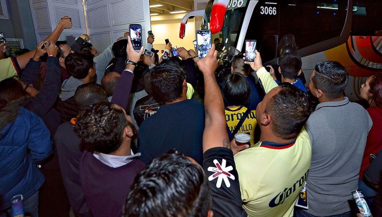 Aficionados del América toman fotos al equipo en su llegada al estadio