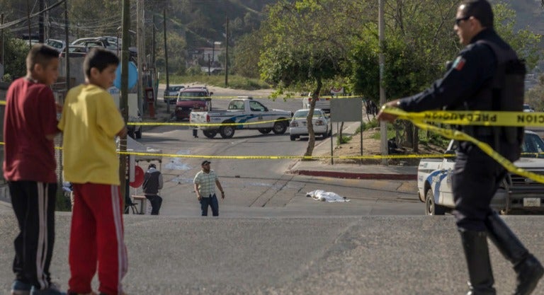 Un policía cierra la calle frente a un homicidio