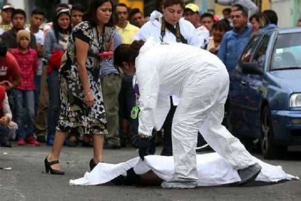 Peritos cubren el cuerpo de una víctima