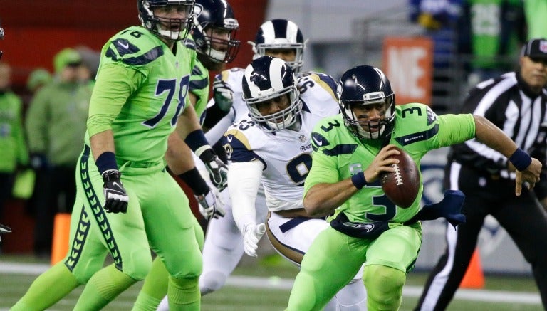 Russell Wilson corre con el balón durante el juego contra Rams