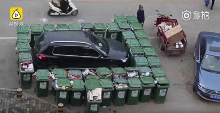 La camioneta rodeada por contenedores de basura