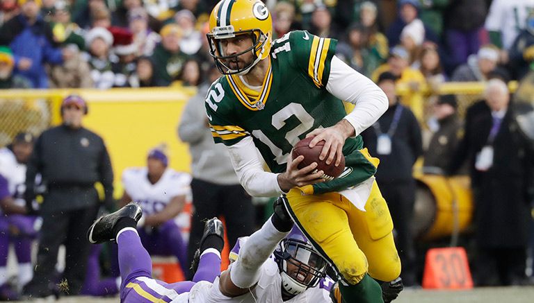 Aaron Rodgers se quita la presión de un defensivo de los Vikings