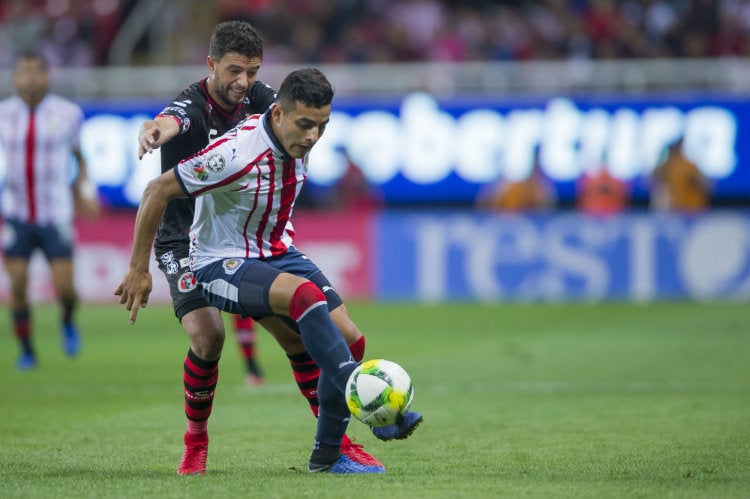 Alexis Vega disputa un balón contra Rivero de Tijuana