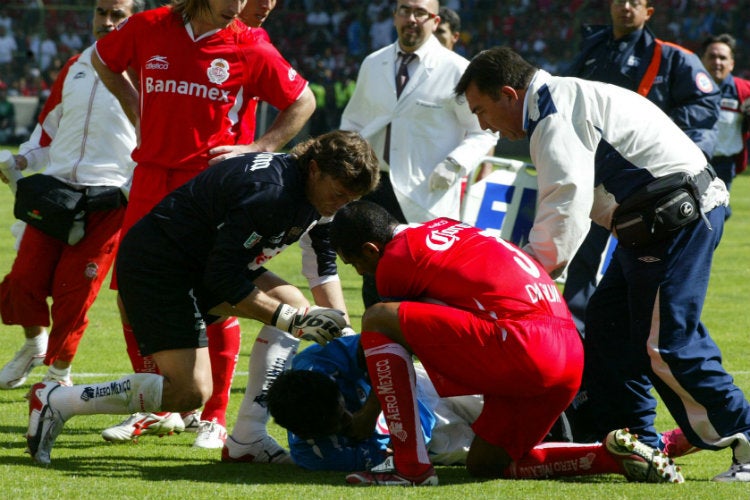 César Villaluz es auxiliado por jugadores de Cruz Azul y Toluca