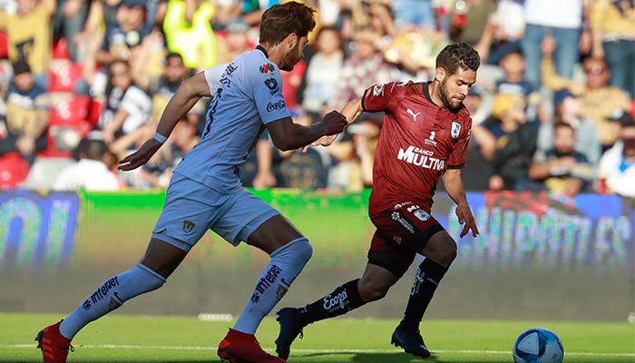 Jugadores de Pumas y Querétaro disputando el balón 