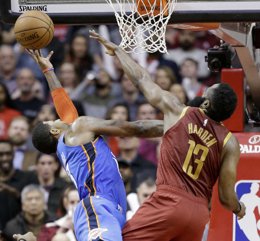 James Harden intenta bloquear el tiro de Paul George