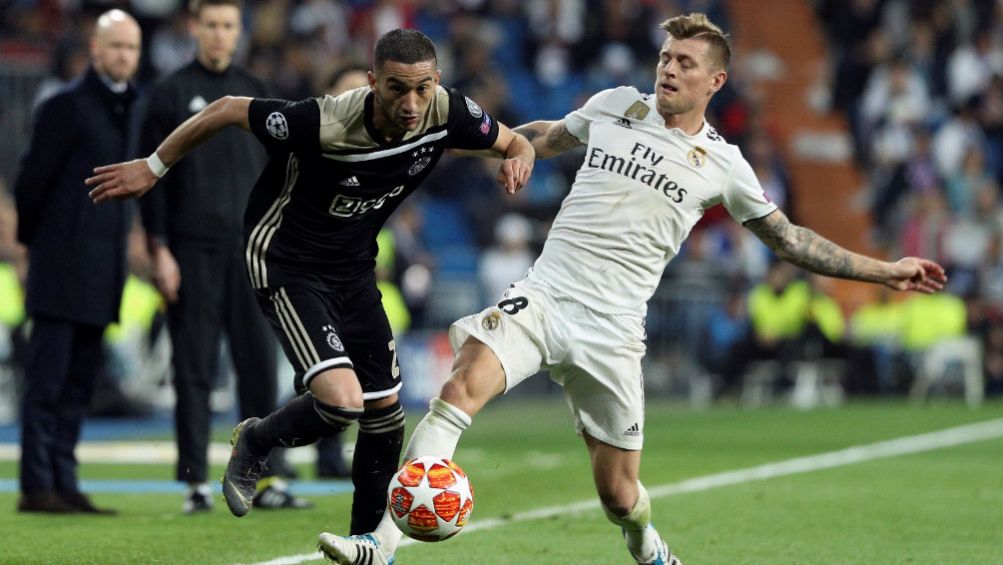 Hakim Ziyech disputan un balón con Toni Kroos