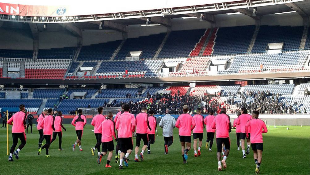 Jugadores del PSG corren ante la mirada de ultras del equipo