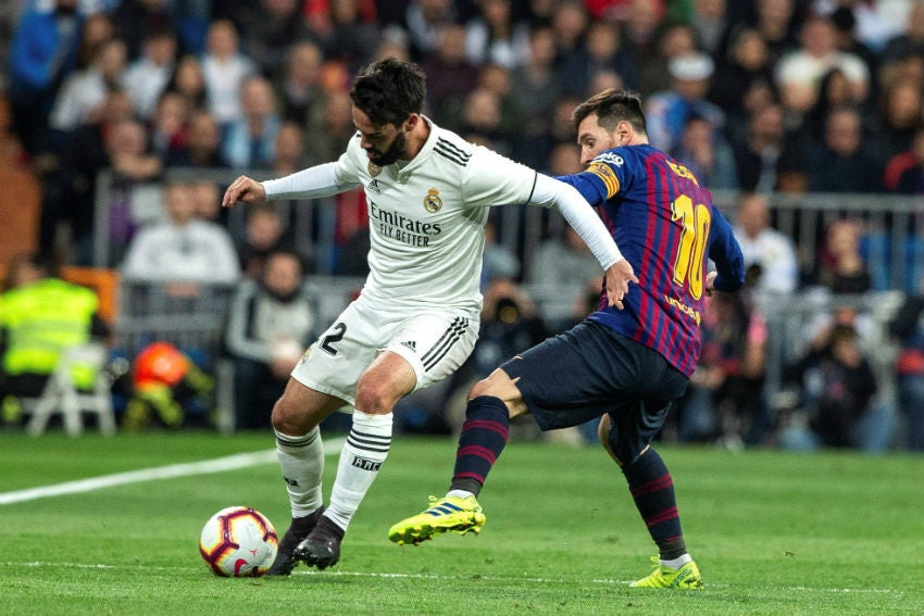 Isco protege el balón de Messi 