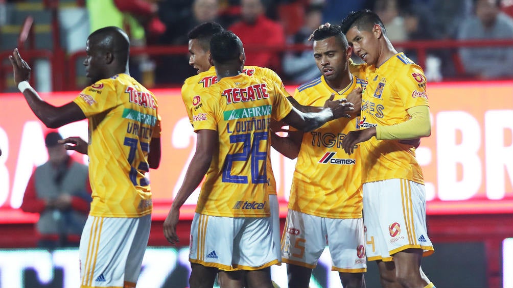 Jugadores de Tigres se abrazan tras una anotación en la Liga MX 