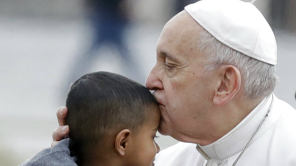 Papa Francisco le da un beso en la frente a un niño 