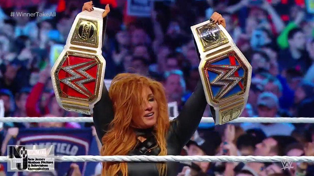 Becky Lynch festeja con ambos campeonatos