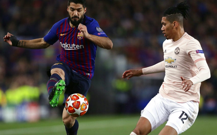 Smalling trata de quitarle el balón a Suárez