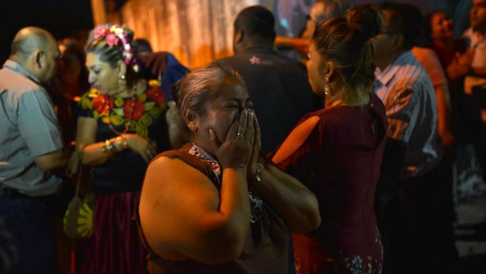  Familiares de las víctimas observan hacia el sitio de la matanza