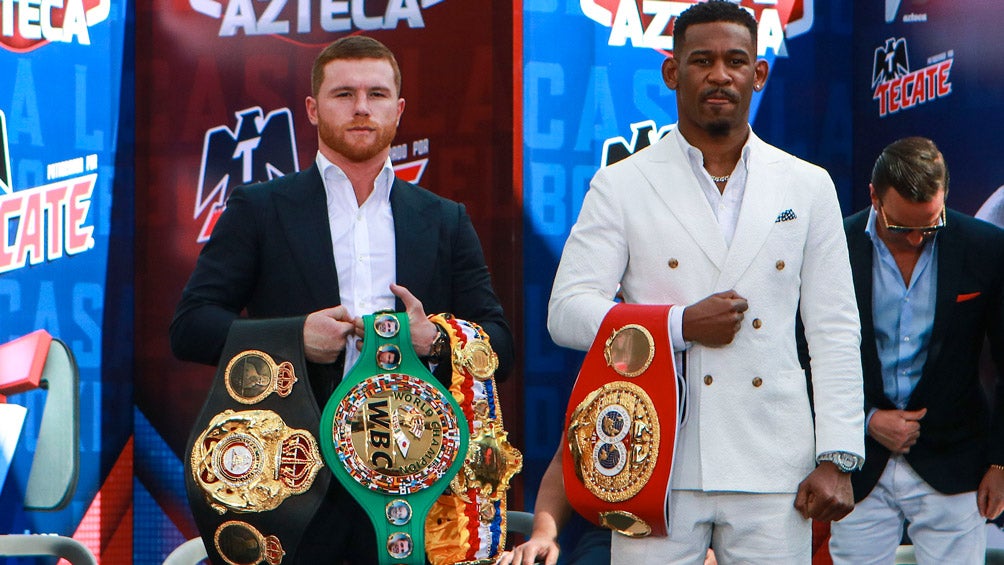 Canelo y Jacobs posan con sus respectivos campeonatos 