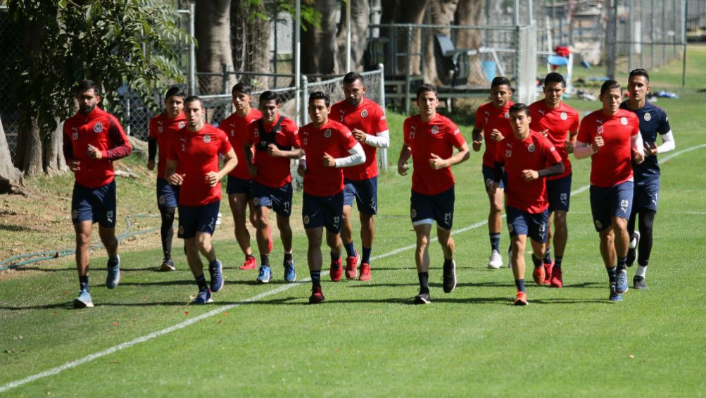 Jugadores de Chivas trotan en una entrenamiento