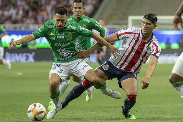 Fernando Navarro pelea el balón con Alan Pulido 